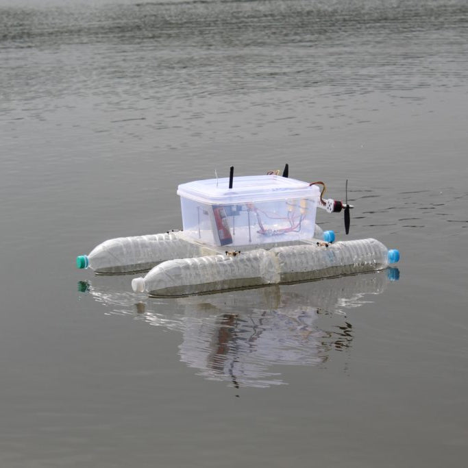 Small-scale autonomous boat made out of recycled water bottles and a Tupperware container